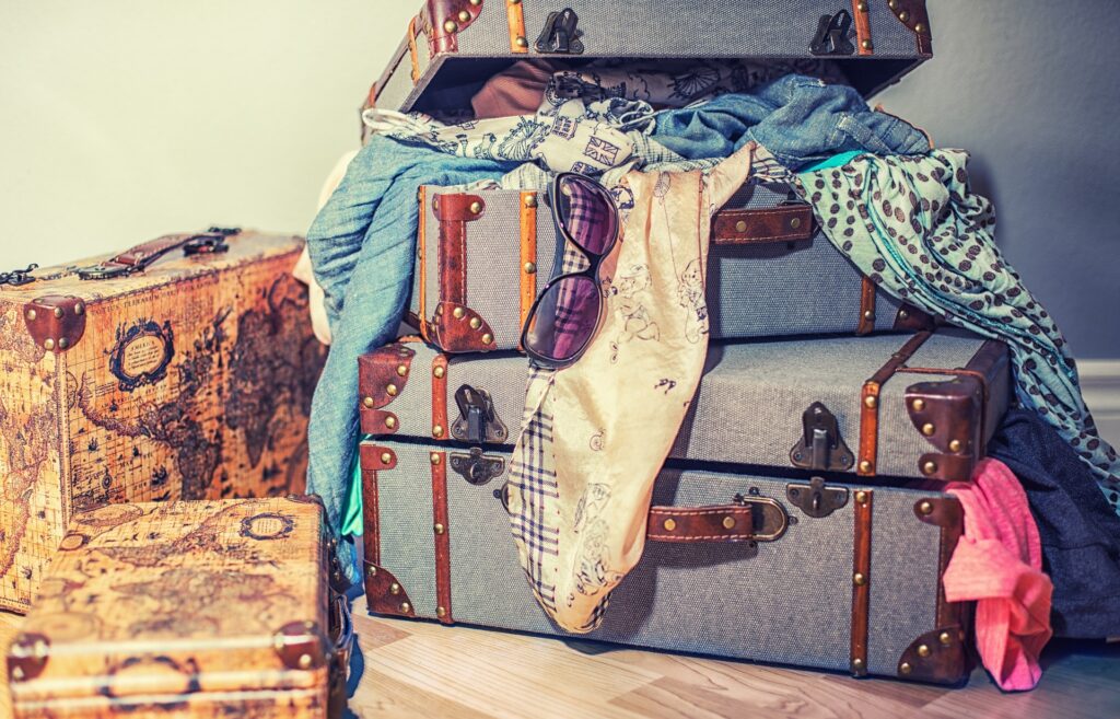 old fashioned suitcases packed messily and clothes sprawling out - packing and unpacking over and over again can make you loose your body awareness practice